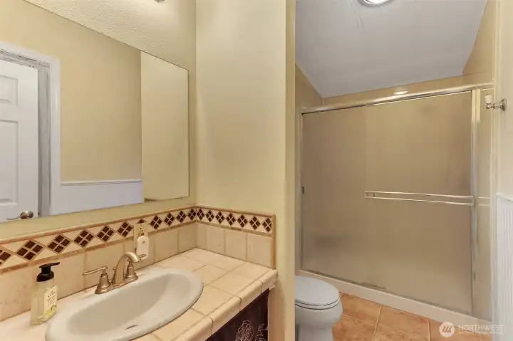 Primary bathroom with oversized 3/4 shower and custom tile counter.