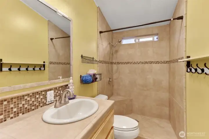 Hall bathroom with fully updated custom tile shower, counter and backsplash.