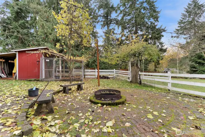 Beautiful and functional firepit with brick surround. Chicken couple behind has a lean-to that would be great to store firewood. Access to the pasture from here as well.