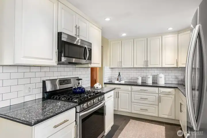 Updated kitchen with granite counters, subway tile backsplash and SS appliances.