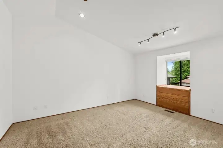 Primary bedroom has a window nook with built in shelving facing the front of the home.
