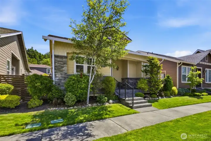 Front Exterior. A tree-lined walkway leads to the covered porch, framed by manicured shrubs and vibrant greenery. Front Exterior. A tree-lined walkway leads to the covered porch, framed by manicured shrubs and vibrant greenery.