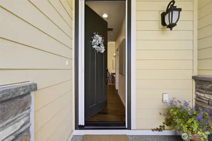 Entry. A rich statement front door opens to a warm welcome, complemented by stone detailing and soft exterior lighting. Entry. A rich statement front door opens to a warm welcome, complemented by stone detailing and soft exterior lighting.