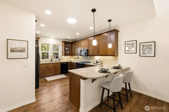 Kitchen. Warm wood cabinetry pairs with a spacious island and pendant lighting for casual dining or meal prep. Kitchen. Warm wood cabinetry pairs with a spacious island and pendant lighting for casual dining or meal prep.