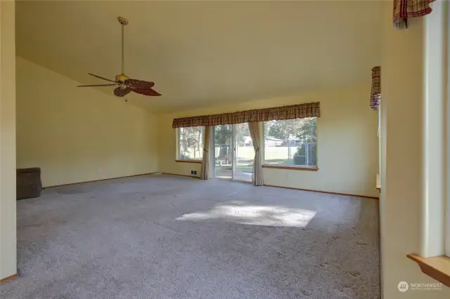 Spacious living room overlooks the golf course and has a slider out to the beautiful back yard sanctuary.