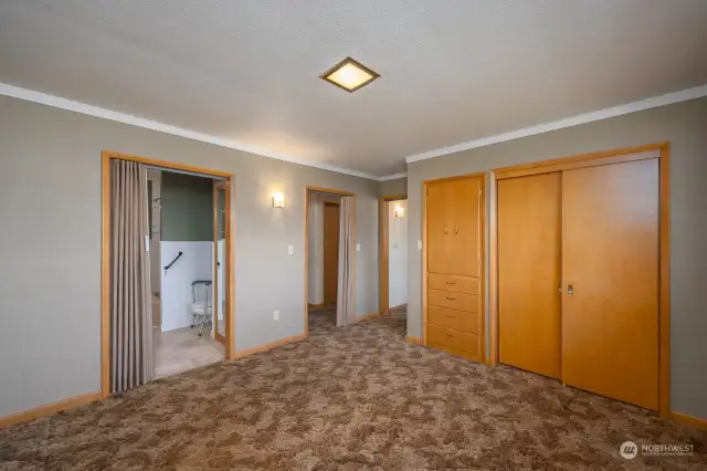 The primary bedroom with a view back to the hallway and adjoining room.