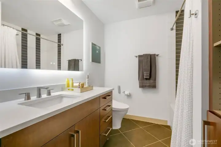 Quartz countertop, sink & faucet fixture and backlit bathroom mirror.