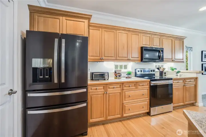 Ample cupboards provide wonderful storage. To the left is the kitchen pantry, to tuck away small appliances, larger food bins, and more.