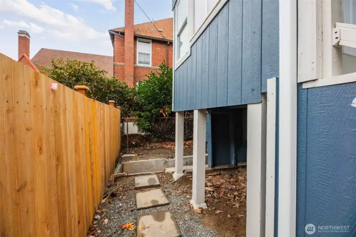 Walkway along the back of the home. New fence.