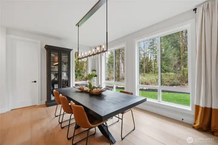 Formal dining with forest and backyard views.