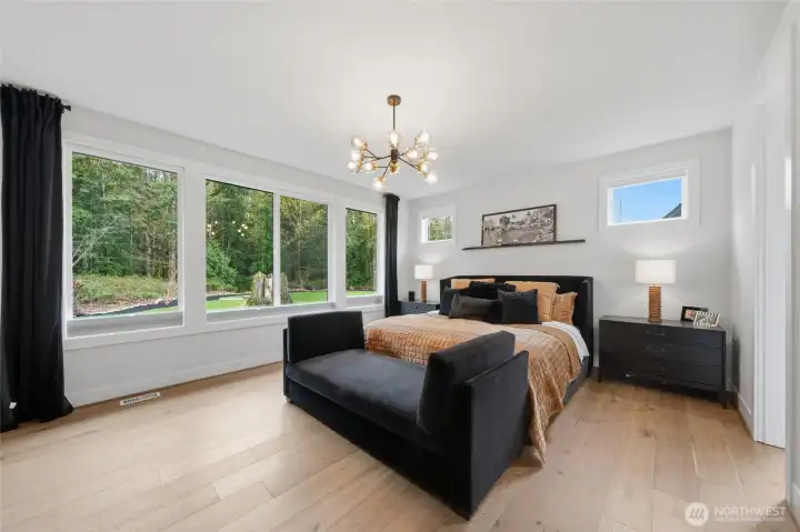 Primary Suite on main floor with private forest and backyard views.