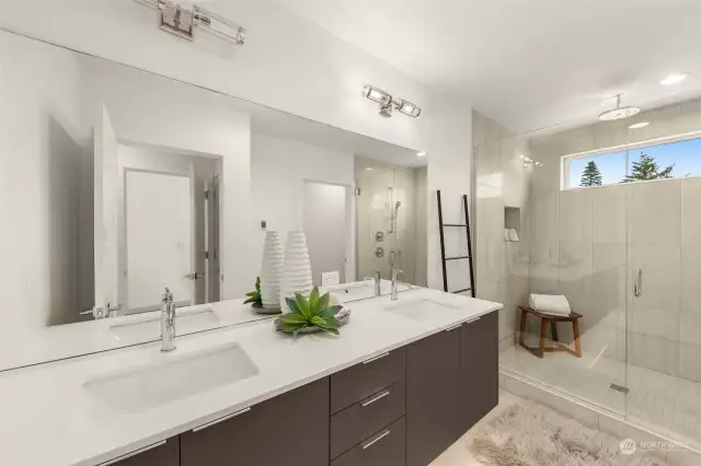 Indulge in the spa-like primary bathroom, complete with dual-sink vanity, sleek finishes, and an expansive walk-in shower that exudes elegance and sophistication.