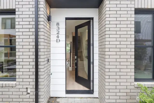 Step into this stylish and contemporary entryway, featuring a sleek door and brick facade that set the tone for the home's modern design.