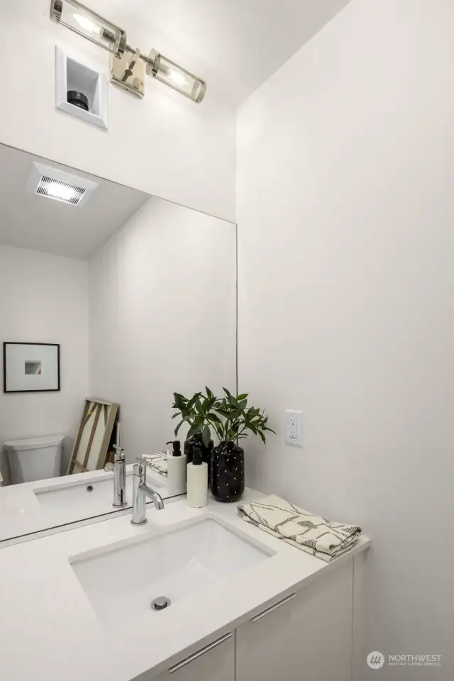 This elegant powder room, with sleek fixtures and a large mirror, offers the perfect blend of style and functionality.