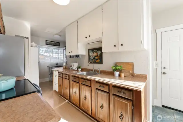 View of kitchen, with eating nook in the back. To the right is the 2nd entrance upstairs and takes you to the back porch.