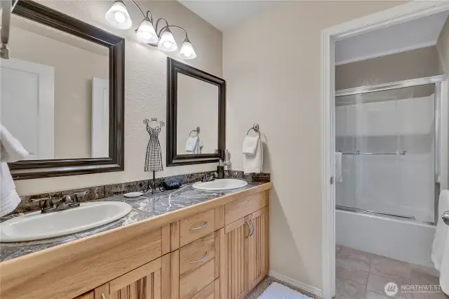 Beautiful granite counters surround the double sinks. The tile flooring is a wonderful addition!