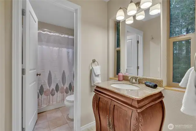 Beautiful cabinet and granite counters in the secondary bathroom. Tile flooring is here as well!