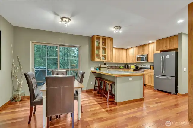 The custom kitchen has hickory cabinets and beautiful granite tile countertops. The sliding glass door from the dining room leads to a large deck facing the private treed area.