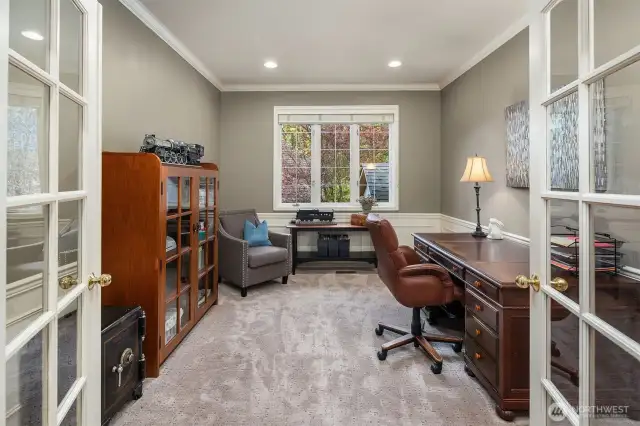 Main floor office with French doors wainscoting and crown molding.