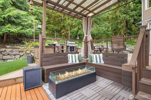 Covered fire pit area is lovely on a summer evening. Curtains surround it when needed for a breeze. Gas is piped in here with built in bench seating.