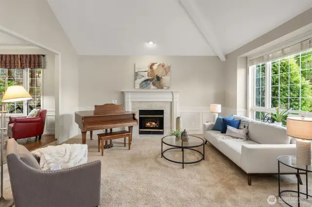 Vaulted living room ceiling with large picture windows and gas fireplace.