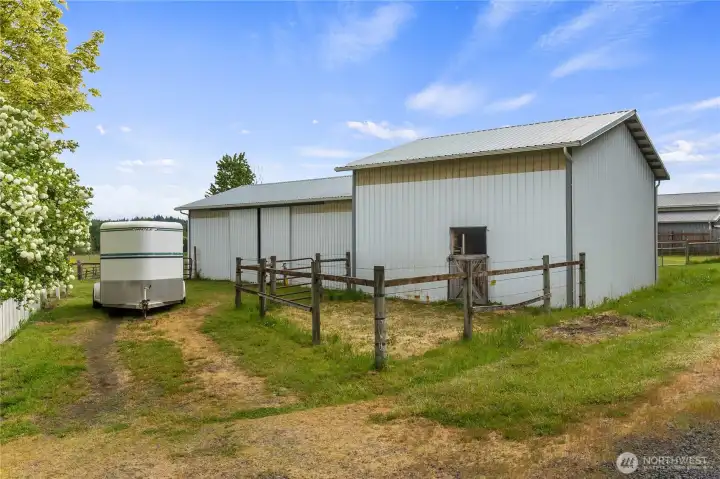 Two barn buildings offer 5 stalls, covered trailer/RV parking and shavings storage and some smaller fenced areas for goats or other critters.