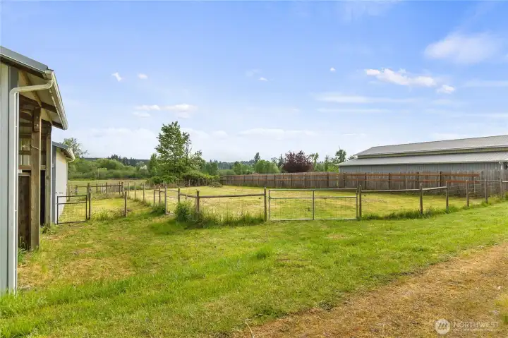 Smaller fenced paddock adjacent to the barn and a larger fenced outdoor area that was previously used as an outdoor riding arena but subsequently converted to additional pasture.