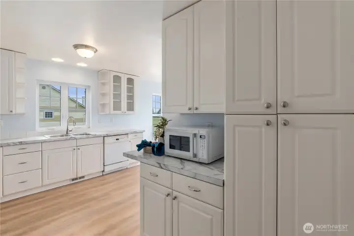 Fresh L shaped kitchen with recently installed LVP flooring.  Airy and bright with lots of counter space and storage. Sunny breakfast nook is around the corner to the right.