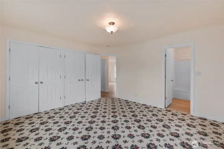 The primary bedroom is on the main level. In addition, the entire house has a total of 3 beds and 2.5 baths.  The primary bath is through the door on the right.  The door straight ahead enters into a hallway, which is just off the living room.