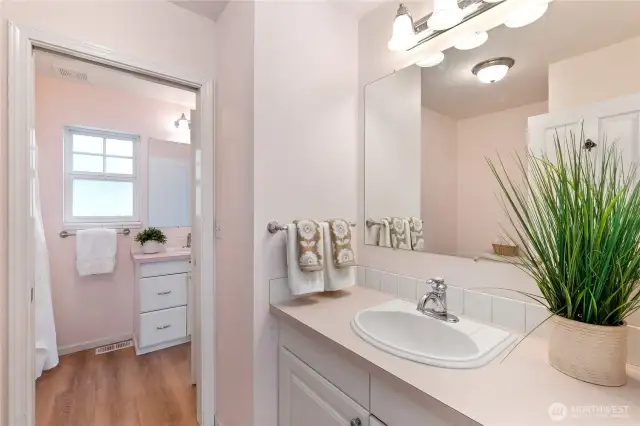 The primary bathroom has two sinks.  One area has a sink and the tub/shower enclosure. A pocket door can be closed to isolate the second sink and water closet guests can access from the living area.