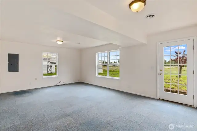 The lower level of the home houses a 2-car garage, this large bonus space with access to the back yard & the laundry room - 1/2 bath. This room is also plumbed for gas which provides the option of adding a 2nd gas fireplace.  Numerous windows bathe the space in natural light. With its own exterior access and downstairs plumbing there may be future MIL options.