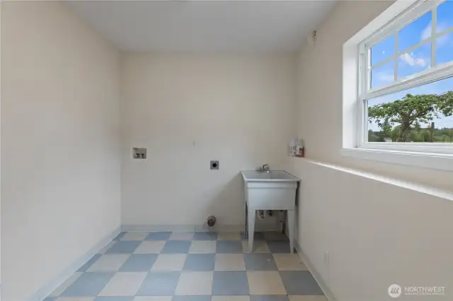 The cheery laundry room with utility sink also has a water closet to the left. Convenient access to outside provides quick clean ups before heading to the main floor.