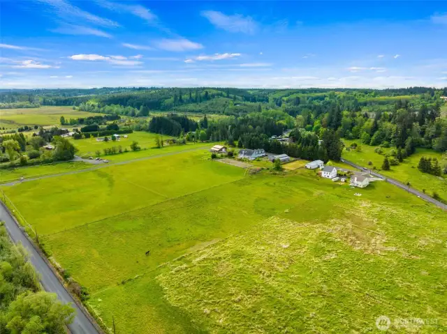 The landscape stretches wide and open & is blanketed in lush, green fields.