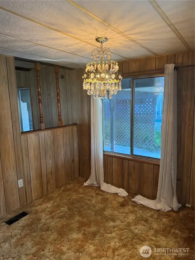 Dining room with half wall leading into family room with pellet stove