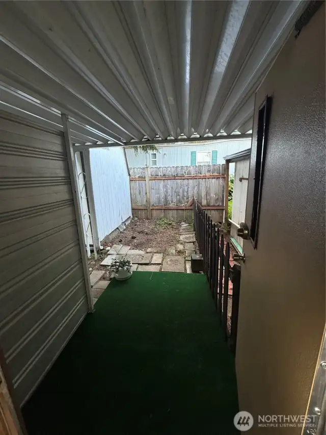 This is a fully covered porch out the back of the house from the hallway across from the bathroom.