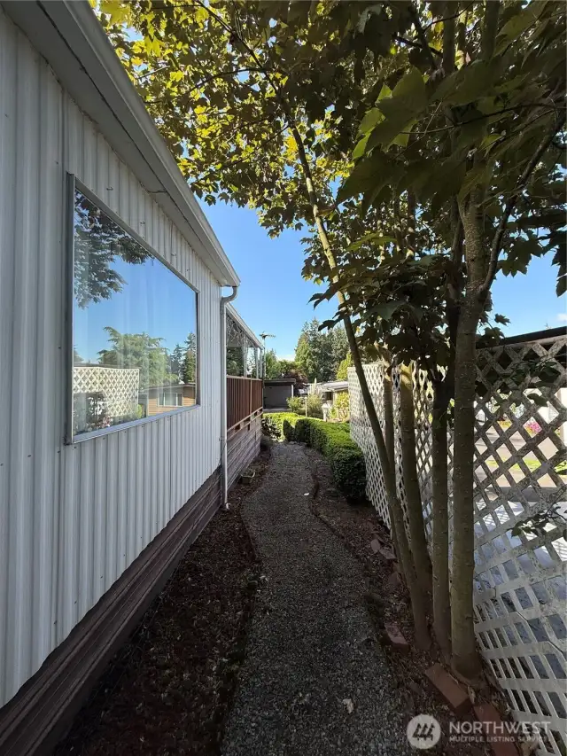 Walkway from backyard to the front of the house and front, covered deck.