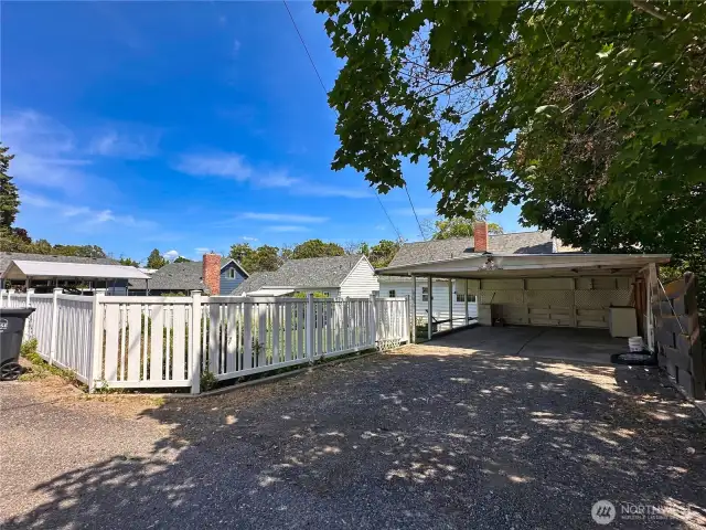 Paved alley leads to 440sf carport with additional driveway parking.