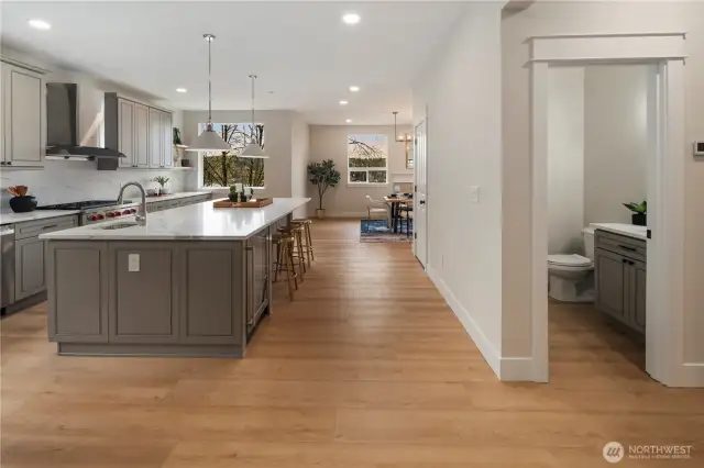 Kitchen leads to dining room with bathroom nearby.