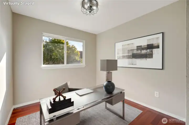 Just down the hall, the generously sized secondary bedroom—currently staged as a home office—adds versatility and function, easily adapting to your lifestyle needs.