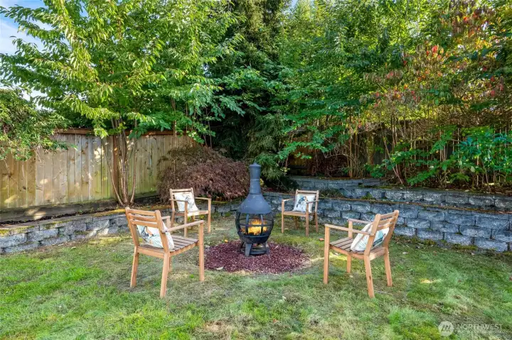 A charming firepit creates the perfect setting for cozy evenings, while a garden area and stands of bamboo add texture, privacy, and character.