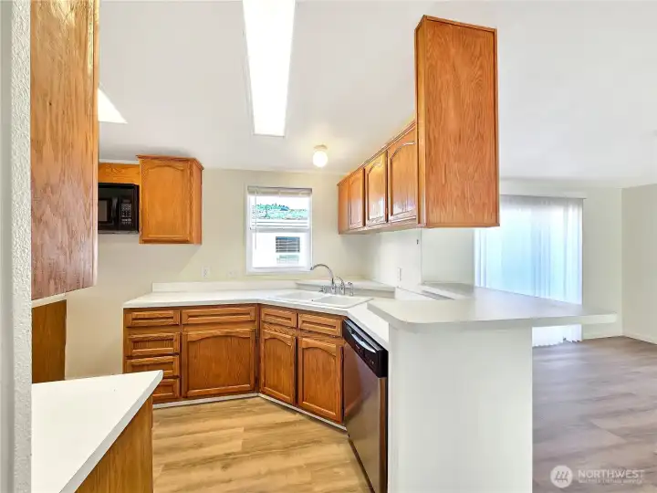 Another view of the kitchen highlighting the cabinetry and functional counter space and bar seating. The range will be installed soon.