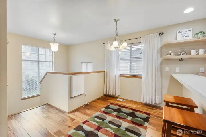 Gleaming wood flooring and a nice dining area greet you in this light filled space. The white unit is environmental convection heating and accents the HVAC heat source