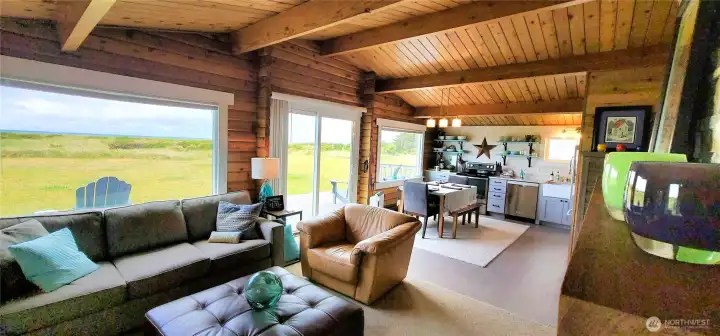 Expansive ocean views seamlessly blend with the open concept living space, where natural light pours in through sliding glass doors, creating a bright and airy coastal retreat.