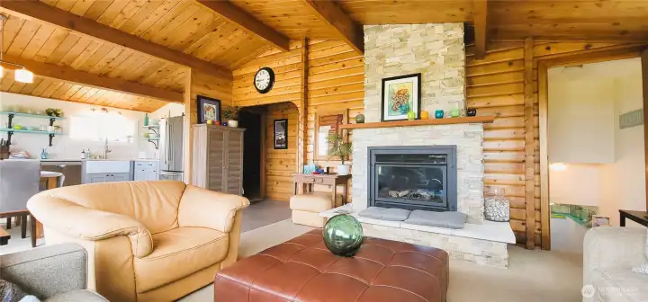 "The striking stone hearth serves as the heart of this inviting space, adding rustic charm and texture to the room. Nestled within, the propane fireplace offers both warmth and convenience, creating a cozy ambiance perfect for relaxation. Together, they blend natural elements with modern comfort, making this a true coastal retreat.