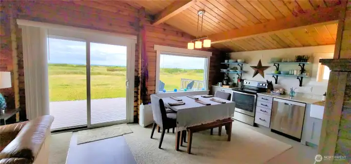 From the great room, expansive windows and sliding glass doors frame breathtaking views of the deck and the vast ocean beyond. Natural light floods the space, seamlessly blending indoor and outdoor living for a serene coastal retreat.