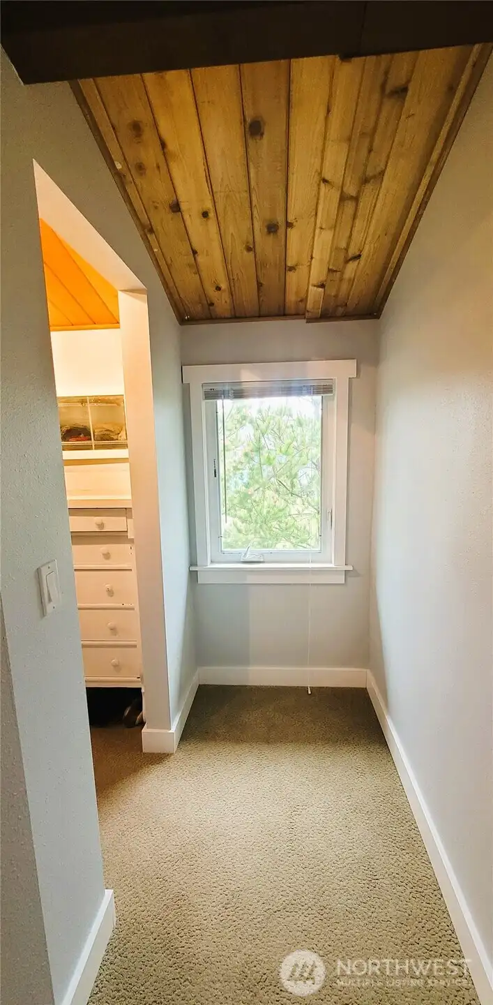 A beautifully designed dressing area leading to the spacious walk-in closet, featuring warm wood accents—creating an elegant and functional space for getting ready in style.