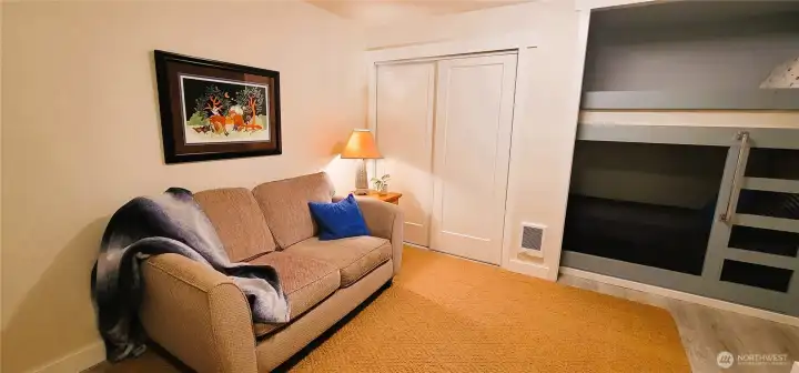 A spacious and versatile bonus room designed for comfort and functionality, offering ample storage alongside cozy bunk accommodations.