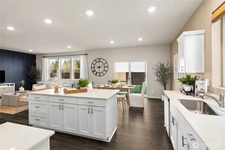 Expansive open-concept kitchen and great room featuring white shaker-style cabinetry, white quartz countertops, large center island and stainless steel undermount sink. Photos are representative only and may display different color package and/or upgrades.