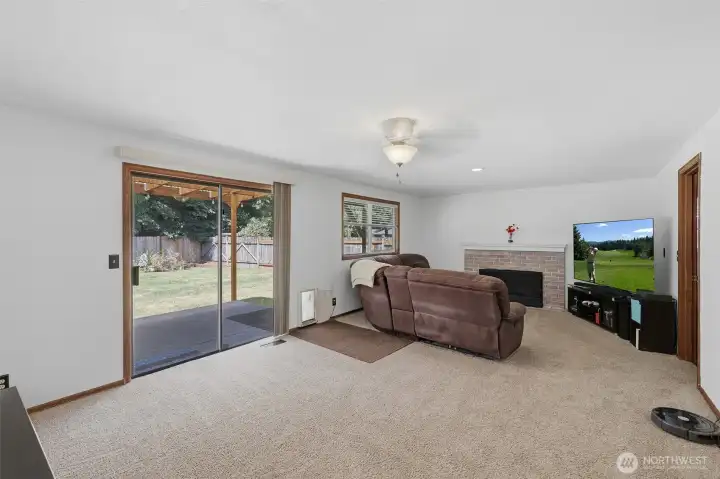 Family room with wood burning fireplace with brick surround. Slider leads to a covered Trex deck. Family room with wood burning fireplace with brick surround. Slider leads to a covered Trex deck.