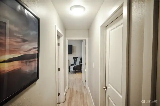 Hallway from living room leads to both bedrooms and guest bathroom